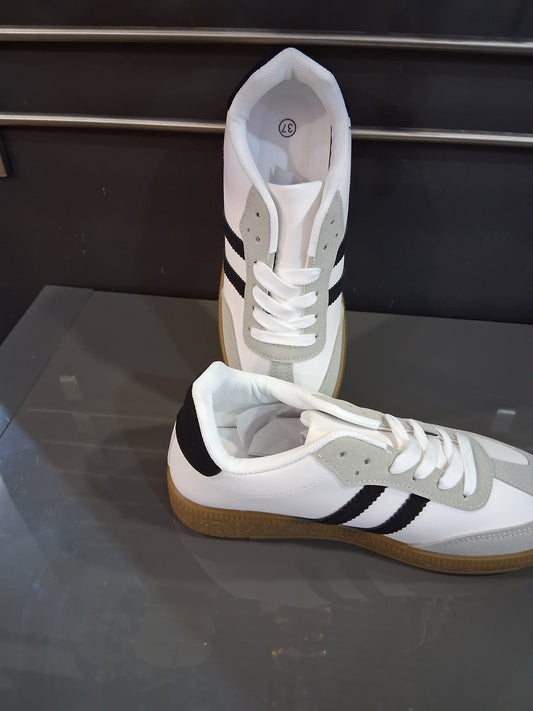 Zapatillas blancas con franjas negras y suela de goma para mujer
